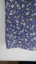 Blue and purple floral scrub top in a wooden frame on a white background
